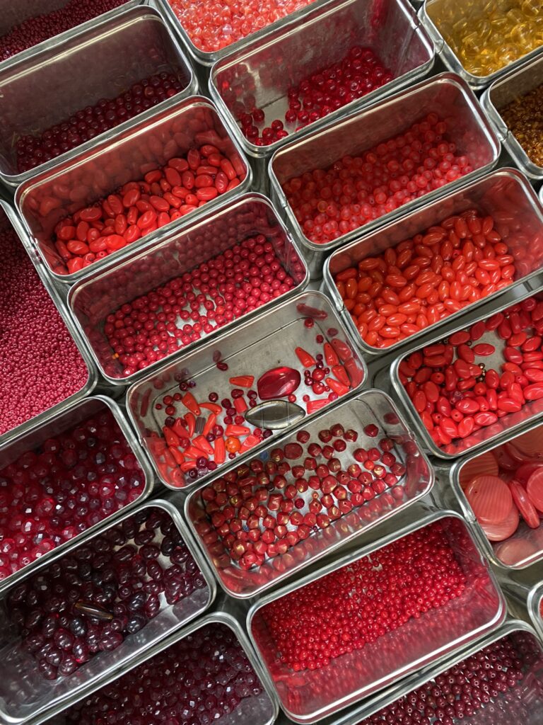 A collection of blue, red, orange, yellow , and multicoloured beads.
