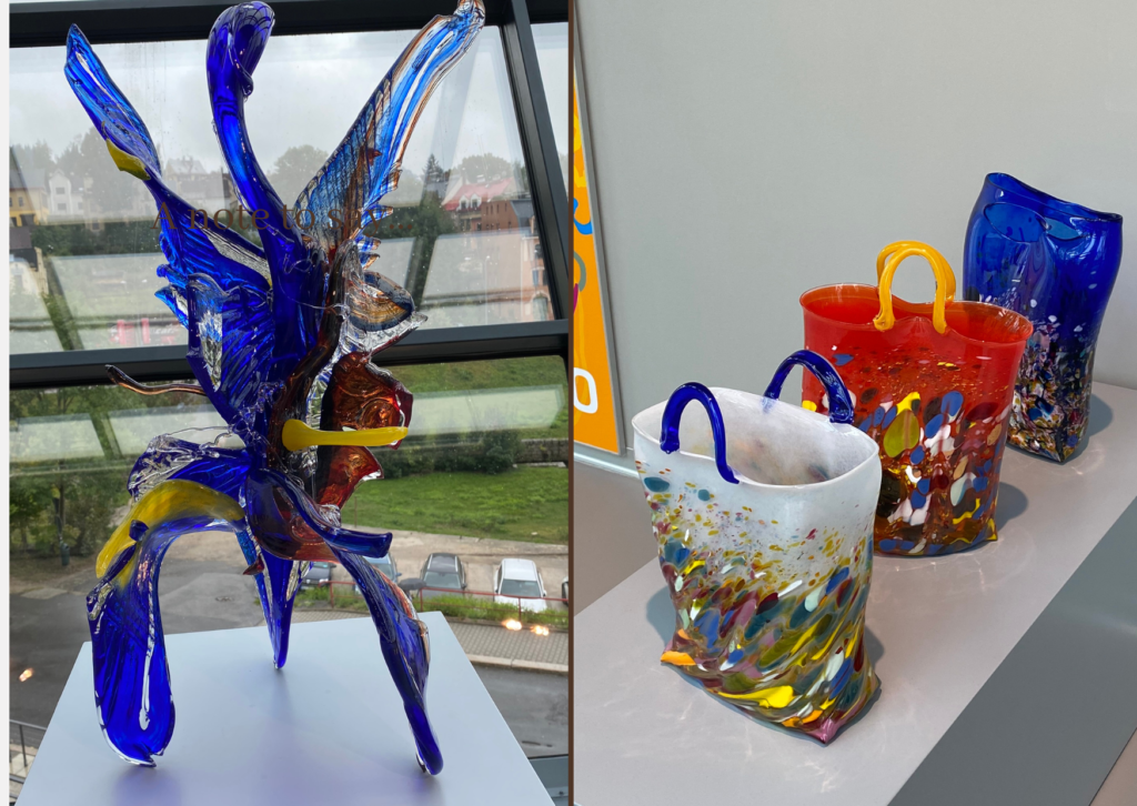 A colourful glass bird sculpture and three different coloured glass bag sculptures on dispaly at the Muzeum skla a bižuterie v Jablonci nad Nisou