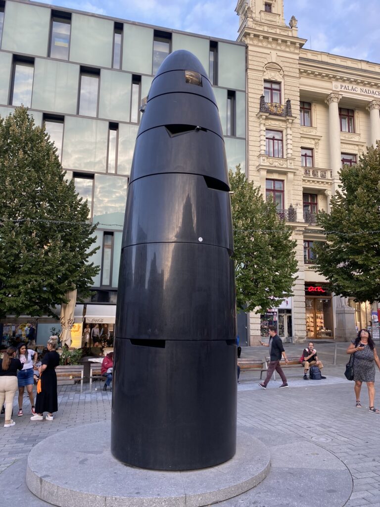 The astronomicalclock in freedom square Brno. A tall black stone monument that houses a clock.