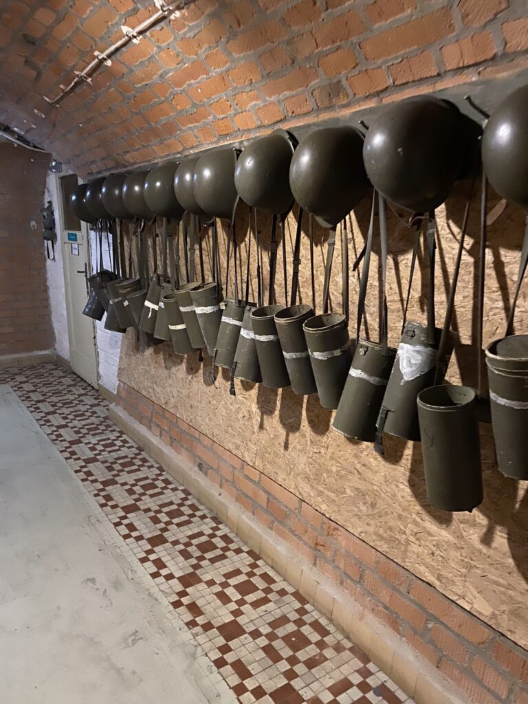 The gas masks and helmets all lines on pegs in the 10-Z Bunker in Brno