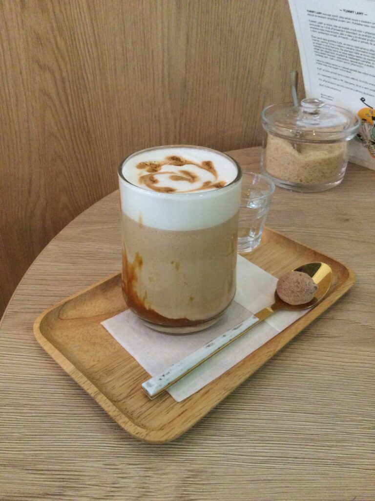 Frothy cappuccino in tall glass at Yummy Lamy Cafe Brno