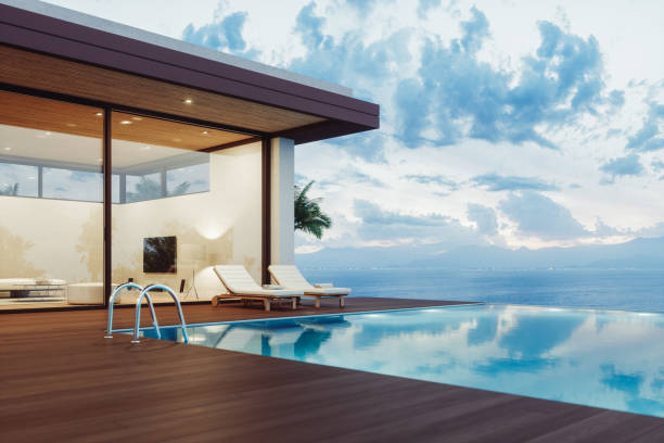 Luxury properties abroad. Modern luxury villa exterior with infinity pool and beautiful ocean view at dawn.