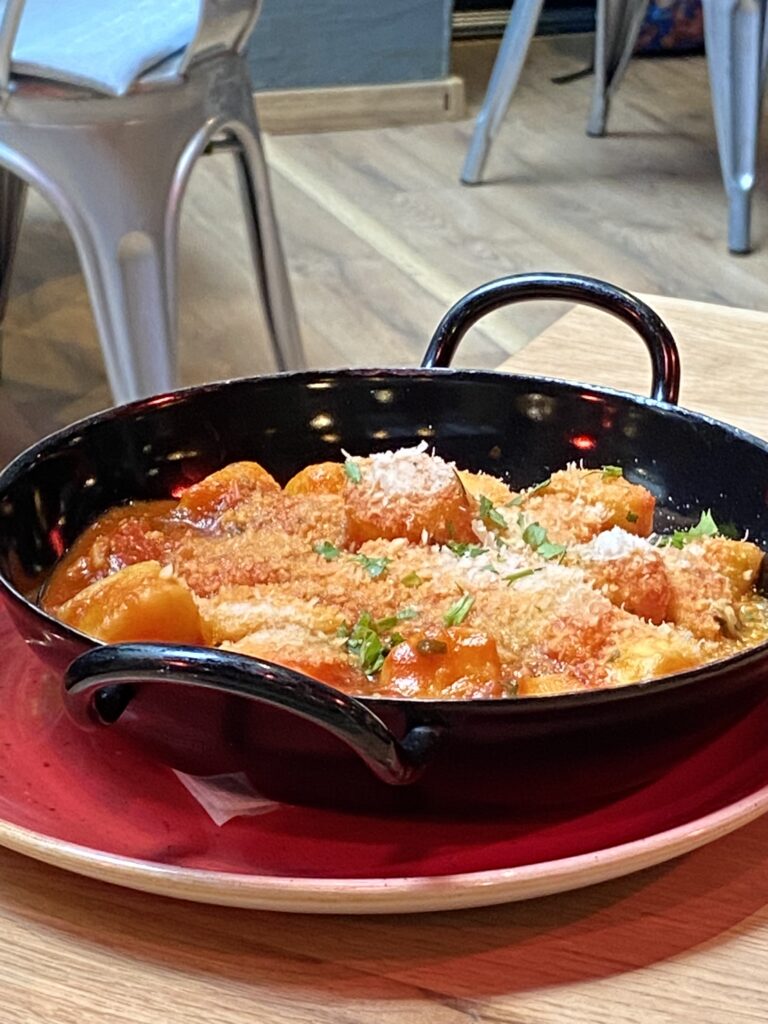Gnocchi in tomato sauce, with cheese and tomatoes.
