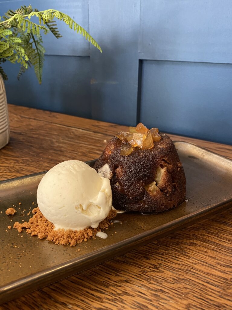 Sticky ginger and apple pudding, served with ginger wine and brandy sauce alongside vanilla ice cream. Delectable desserts at The Duke on the Test Inn Romsey