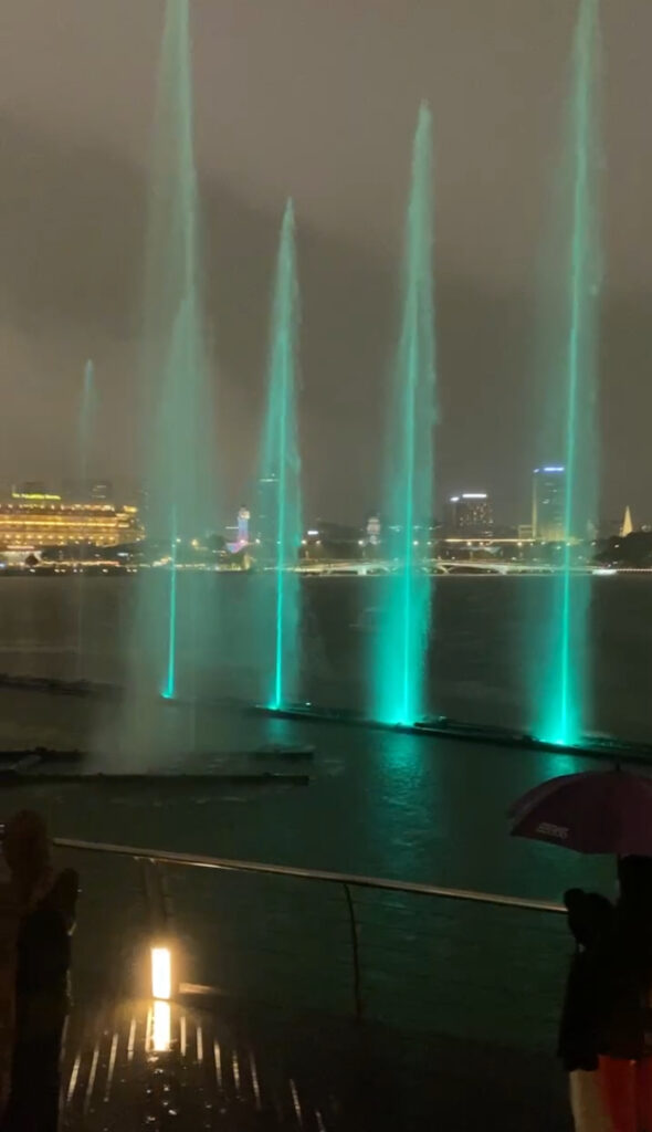 colourful green lights dancing on the water at Spectra light and fountain show.